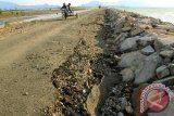 Becak mesin melintasi jalan pantai yang rusak diterjang gelombang pasang di kawasan Pantai Kota Banda Aceh, Rabu (29/7). Jalan pantai yang dibentengi tanggul menghubungkan desa pesisir kampung Jawa dengan pelabuhan penyeberangan Ulee Lheue, Banda Aceh itu, masih dalam tahap penyelesaian , namun sebagian badan jalan rusak akibat gelombang pasang. ACEH.ANTARANEWS.COM/Ampelsa/15