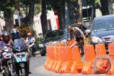 Seorang anggota Polisi Lalu Lintas Polrestabes Surabaya memasang tali rambu pemisah di Jalan Basuki Rahmat Surabaya, Selasa (4/8). Rambu pemisah dipasang untuk mengurai kemacetan lalu lintas di kawasan Tunjungan Plaza. Foto Antara Jatim/Fiqih Arfani