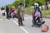 Petugas Wilayatul Hisbah (WH) Dinas Syariat Islam Provinsi Aceh, menghentikan sejumlah pengemudi sepedamotor yang mengenakan celana ketat saat berlangsung razia penegakan syariat di Banda Aceh, Kamis (6/8). Puluhan warga yang  terjaring dalam razia penertiban busana muslim itu mendapat peringatan dari petugas  Dinas Syariat Islam Aceh dan bagi mereka yang masih melakukan pelanggaran  akan dikenakan sanksi.  ACEH.ANTARANEWS.COM/Ampelsa/15