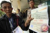 Warga menunjukkan blanko Surat Keterangan Pengganti Surat Ijin Mengemudi (SIM) di Satpas Colombo  Surabaya, Jawa Timur, Kamis (6/8). Surat keterangan pengganti SIM sementara yang khusus diperuntukkan bagi warga yang memperpanjang SIM tersebut akibat menipisnya stok material SIM. Antara Jatim/Didik Suhartono/zk/15