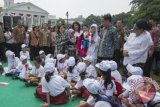 Presiden Joko Widodo (kedua kanan) didampingi Ibu Negara Ny. Iriana Joko Widodo (keempat kanan), Ibu Mufidah Jusuf Kalla (kelima kanan), Menko Pembangunan Manusia dan Kebudayaan Puan Maharani (keenam kanan) dan Menteri PPPA Yohana Yembise (kanan) mengunjungi gerai Kampung Dongeng pada acara puncak Peringatan Hari Anak Nasional Tahun 2015 di Istana Bogor, Jawa Barat, Selasa (11/8). (Foto Antara/ Widodo S Jusuf)