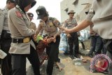 Polisi mengamankan seorang ibu yang dianggap mengganggu serta membahayakan petugas saat dilakukannya pengosongan lahan di Tembok Dukuh, Surabaya, Jawa Timur, Rabu (12/8). Pengosongan lahan seluas 1.119 meter persegi bekas gudang yang sudah diruntuhkan tersebut diwarnai dengan sedikit  kericuhan. Antara Jatim/Didik Suhartono/zk/15