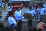 Direktur Utama PT Taspen saat menyerahkan doorprize kepada salah satu pemenang undian,  peserta jalan sehat, Minggu (16/8) pagi. Jalan Sehat BUMN Hadir Untuk Negeri dalam rangkaian HUT Ke-70 Republik Indonesia, yang diperembahkan oleh BUMN se-Gorontalo, dengan lokasi star dan finish dilapangan Taruna Remaja Kota Gorontalo.