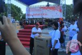 Direktur Umum PT Taspen saat menyerahkan doorprize kepada salah satu pemenang undian,  peserta jalan sehat, Minggu (16/8) pagi. Jalan Sehat BUMN Hadir Untuk Negeri dalam rangkaian HUT Ke-70 Republik Indonesia, yang diperembahkan oleh BUMN se-Gorontalo, dengan lokasi star dan finish dilapangan Taruna Remaja Kota Gorontalo.