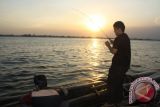 Dua warga Banjarmasin mengisi liburan dengan memancing di Sungai Barito, Alalak Selatan, Senin (17/8). Sejak satu bulan terakhir air di Sungai Barito menjadi asin karena intrusi air laut.(Foto Antaranews Kalsel/Asmuni) 