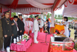 Bupati Bone Bolango Hamim Pou saat bertindak sebagai Irup HUT RI 17 Agustus, menyerahkan bendera ke anggota Paskibra untuk dikibarkan. (foto ist)