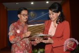 Menteri Agraria dan Tata Ruang/Kepala BPN Ferry Mursyidan Baldan (kiri) bertukar naskah dengan Ketua Umum Kongres Wanita Indonesia (Kowani) Giwo Rubianto Wiyogo (kanan) saat penandatanganan nota kesepahaman (MoU) di Jakarta, Selasa (18/8). Kerjasama tersebut terkait legalisasi aset-aset Kowani dan organisasi kewanitaan lainnya. ANTARA FOTO/Prasetyo Utomo/wdy/15