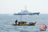 Sebuah kapal kecil melewati Kapal patroli Hiu Macan Tutul 002 dari Kementerian Kelautan dan Perikanan di Perairan Pulau Lemukutuan, Kabupaten Bengkayang, Kalbar, Selasa (18/8). KKP secara rutin melakukan patroli di perairan Indonesia untuk memantau aktivitas pencurian ikan yang dilakukan kapal nelayan asing atau penangkapan ikan secara ilegal dengan menggunakan pukat harimau. ANTARA FOTO/Jessica Helena Wuysang/15