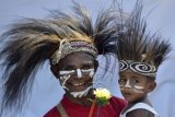 Warga dengan pakaian tradisional Papua mengikuti peringatan Hari Anak Nasional Ke-31 di Jayapura, Papua, Jumat (21/8). Kegiatan tersebut merupakan salah satu upaya pemerintah dalam meningkatkan kesejahteraan anak-anak yang nantinya diharapkan mampu menjadi generasi berdedikasi dan berguna di masa mendatang. ANTARA FOTO/Sigid Kurniawan/pd/15.
