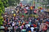 Presiden Joko Widodo (kiri) didampingi Ibu Negara Iriana Joko Widodo (kedua kiri) serta Gubernur Kalbar Cornelis (kanan) menyapa warga saat berpawai dalam rangkaian Karnaval Khatulistiwa 2015 di Jalan Teuku Umar, Pontianak, Kalimantan Barat, Sabtu (22/8). Karnaval Khatulistiwa 2015 dalam rangka puncak peringatan HUT ke-70 Kemerdekaan RI diikuti 24 Propinsi yang terdiri dari karnaval darat 4075 orang, karnaval air 1535 orang, mobil hias 145 armada, kapal hias 251 armada, 100 sepeda ontel hias, dan 50 motor hias. ANTARA FOTO/Yudhi Mahatma/wdy/15