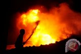 Puluhan toko dan kios di Pasar Tengah, Pontianak, ludes terbakar Jumat (21/8) malam. Tampak seorang petugas pemadam berjibaku memadamkan api di salah satu kawasan tua di Kota Pontianak itu. (Jessica H Wuysang)