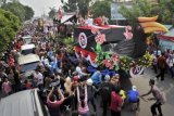 Presiden Joko Widodo (kiri) bersama Gubernur Kalbar Cornelis (kanan), serta musisi Abdee Slank (tengah) menyapa warga saat berpawai dalam rangkaian Karnaval Khatulistiwa 2015 di Jalan Teuku Umar, Pontianak, Kalimantan Barat, Sabtu (22/8). Karnaval Khatulistiwa 2015 dalam rangka puncak peringatan HUT ke-70 Kemerdekaan RI diikuti 24 Propinsi yang terdiri dari karnaval darat 4075 orang, karnaval air 1535 orang, mobil hias 145 armada, kapal hias 251 armada, 100 sepeda ontel hias, dan 50 motor hias. ANTARA FOTO/Yudhi Mahatma/kye/15
