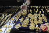Seorang pedagang menata perhiasan emas di Kawasan Cikini, Jakarta, Selasa (25/8/15). Kenaikan harga emas di pasaran internasional yang dipengaruhi salah satunya penguatan dolar AS berdampak pada lonjakan harga emas di toko emas, harga emas perhiasan dijual berkisar Rp420 ribu per gram dengan kadar emas 75 persen atau naik sekitar Rp10 ribu - Rp20 ribu per gram. (ANTARAFOTO/Wahyu Putro A)