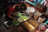 Seorang pekerja membuat kue di industri kue rumahan milik Rahmatiah yang dibiayai PNM di Kelurahan Sungai Bilu Banjarmasin, Rabu (26/8).  Hingga Juni 2015, secara nasional PT. Permodalan Nasional Madani menyalurkan 14 trilyun rupiah modal usaha kepada 230 ribu nasabahnya di seluruh Indonesia, sementara di Kalsel 417 milyar rupiah dengan 20.152 nasabah. Antarafoto/Herry Murdy Hermawan