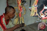 Perajin membuat kerajinan wayang kulit di Trenggalek, Jawa Timur, Jumat (28/8). Kerajinan wayang dengan bahan baku kulit kambing dijual dengan harga di kisaran Rp250 ribu hingga Rp750 ribu per buah sementara untuk wayang dengan bahan kulit sapi dijual dengan harga di kisaran Rp800 ribu hingga Rp1.500 ribu per buah. ANTARA FOTO/Destyan Sujarwoko/zk/15