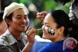 Seorang seniman mengoleskan cat pada wajah perempuan dalam aksi \'body painting\' di Kantor WWF-Indonesia Program Kalbar, di kawasan Kota Baru, Pontianak, Kalbar, Jumat (28/8). Aksi Body Painting tersebut, merupakan rangkaian kegiatan dari pembukaan Panda Shop WWF-Indonesia Program Kalbar. ANTARA FOTO/Jessica Helena Wuysang/15