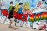 Seniman pelukis tembok (grafity atau mural) dari komunitas Atjeh Slankers Club Streetart melukis Hari Keluarga Nasional (Harganas) ke XII di Banda Aceh, Aceh, Selasa (1/9). Seni coretan di tembok terus berkembang di seluruh Indonesia terutama kota-kota besar meskipun para pegiat kebersihan tidak setuju dengan seni tersebut dengan alasan mengotori tembok dan sering divonis sebagai aksi merusak. ANTARA FOTO/Irwansyah Putra/foc/15.