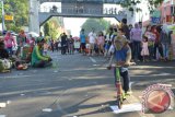 Seekor kera dalam kondisi terikat tali menaiki sepeda Po saat diajak mengamen pemiliknya di areal hari tanpa kendaraan bermotor (Car Free Day) di Kota Madiun, Jawa Timur, Minggu (6/9). Meski ditentang para pencinta binatang, ekspolitasi kera untuk mencari uang bagi pemiliknya yang dikemas dalam bentuk hiburan topeng monyet masih terus terjadi. Antara Jatim/Foto/Siswowidodo/ZK/15