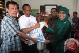 Menteri Sosial RI Khofifah Indar Parawansa simbolis menyerahkan bantuan beras untuk keluarga sejahtera (Rastra) di Kelurahan Kampungdalem, Tulungagung, Jawa Timur, Minggu (6/9). Sejak awal Agustus pemerintah telah menginstruksikan percepatan surat perintah alokasi (SPA) Rastra bulan September-Oktober guna mempercepat pencairan Rastra ke-13 sebagai upaya penguatan bantalan sosial bagi masyarakat kurang mampu. Antara Jatim/Foto/Destyan Sujarwoko/zk/15