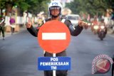 Petugas Subdenpom V/1-6 memberi isyarat lalu lintas saat digelarnya razia gabungan TNI/Polri di jalan raya Tulungagung, Jawa Timur, Rabu (9/9). Razia gabungan tersebut digelar sebagai rangkaian operasi pekan disiplin TNI/Polri di jalan raya guna mencegah penyalahgunaan nomor register/stiker berlogo TNI/Polri serta peredaran senjata api ilegal. Antara Jatim/Foto/Destyan Sujarwoko/zk/15