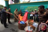 Kepala Kejaksaan Negeri Ambon Roberth Ilath (kedua kiri) didampingi Kasat Reskrim Polres Pulau Ambon dan Pulau-pulau Lease AKP Theodorus Priyo Santoso (kiri) memusnahkan barang bukti narkotika dan sejumlah barang bukti lainnya di Ambon, Maluku, Selasa (8/9). Barang bukti yang dimusnahkan berasal dari 56 perkara yang terdiri dari berbagai jenis narkotika, bendera organisasi RMS dan sejumlah peralatan lainnya. ANTARA FOTO/Izaac Mulyawan/kye/