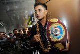 Petinju Indonesia asal Kalbar, Iwan Soda memegang sabuk kemenangan saat tiba di Bandara Supadio, Kabupaten Kubu Raya, Kalbar, Senin (7/9). Iwan Soda juara pada Kejuaraan Tinju WBO Asia 50,99 kilogram, setelah menang KO atas Petinju Thailand, Petchchorhae Kokietgym di Thailand pada Kamis (3/9). ANTARA FOTO/Jessica Helena Wuysang/ama/15