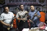 Kabid Humas Polda Aceh Kombes Pol Saladin (tengah) didampingi Wakil Direktur Reserse Kriminal Umum, AKBP Subegti (kanan) menghadirkan barang bukti berupa tiga pucuk senjata api laras panjang dan amunisinya serta enam tersangka kelompok besenjata saat gelar perkara di Banda Aceh, Jumat (11/9). Polisi menangkap lima kelompok bersenjata di rumah dinas DPRA yang berencana akan membebaskan temannya, terdakwa bandar narkoba Abdullah dalam kasus penyeludupan sabu sebanyak 78 kilogram yang ditahan di Lembaga Permasyarakatan, Banda Aceh. ACEH.ANTARANEWS.COM/Ampelsa/15.