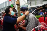 Ketua Palang Merah Indonesia (PMI) Provinsi Kalbar, Frederika Cornelis (kiri) memasangkan masker kepada pengemudi becak, saat sosialisasi penggunaan masker di Pasar Flamboyan, Pontianak, Kalbar, Jumat (11/9). Selain membagikan 35 ribu masker untuk warga, PMI Kalbar juga melakukan sosialisasi tentang pentingnya menggunakan masker agar dapat terhindar dari penyakit Infeksi Saluran Pernafasan Atas (ISPA) akibat menghirup polusi asap pembakaran lahan. ANTARA FOTO/Jessica Helena Wuysang/15


