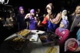 Warga mencicipi masakan ikan nike (ikan khas Gorontalo) hasil tangkapan nelayan saat Festival Duwo di Gorontalo, Selasa (8/9) malam. Festival Duwo tersebut diselenggarakan sebagai rangkaian perayaan Sail Tomini 2015. (ANTARA FOTO/Yusran Uccang)