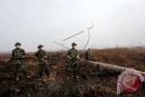 Tiga orang prajurit TNI AD menyemprotkan air ke lahan gambut yang terbakar di Desa Condong, Pampangan, Ogan Komering Ilir (OKI), Sumsel. Minggu (13/9). Berdasarkan pantauan citra satelit AQUA/TERRA MODIS milik BMKG Provinsi Sumatera Selatan penyumbang titik api terbanyak dengan 373 titik dibandingkan Provinsi di Pulau Sumatra. ANTARA FOTO/Nova Wahyudi/wdy/15