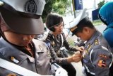 Seorang Polwan merapikan pakaian anggota Polisi Cilik (Pocil), saat Lomba Keterampilan Pocil, di Padang, Sumatera Barat, Minggu (13/9). Lomba Pocil tersebut melibatkan anak-anak tingkat sekolah dasar (SD) di Sumbar dalam rangka HUT Polisi Lalulintas ke-60. ANTARA FOTO/Iggoy el Fitra/nz/15