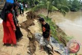 Sejumlah warga melihat kawasan tanggul yang amblas ke sungai pasca terjadi banjir akibat jebolnya tanggul aliran sungai Krueng Pase, Desa Mancang, Samudera Geudong, Aceh Utara, Provinsi Aceh, Minggu (13/9). Warga yang tinggal di kawasan itu was-was dengan kondisi tanggul aliran sungai tersebut yang rusak parah sementara belum ada penanganan serius dari pemerintah setempat. ANTARA FOTO/Rahmad/foc/15.
