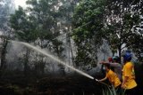 Petugas pemadam kebakaran memadamkan api di atas lahan gambut yang terbakar di Jalan Perdana, Pontianak, Kalbar, Senin (14/9). Walaupun Polda Kalbar sudah mengeluarkan Maklumat Kepolisian tentang larangan pembakaran hutan dan kebun dengan ancaman hukuman penjara minimal 3 tahun dan maksimal 10 tahun penjara serta denda 15 miliar rupiah, tapi hingga kini masih terjadi pembakaran lahan gambut yang dilakukan secara sengaja di wilayah Kalbar. ANTARA FOTO/Jessica Helena Wuysang/aww/15.