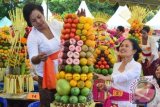 Peserta merangkai buah saat mengikuti lomba merangkai gebogan di Renon, Kota Denpasar, Bali, Jumat (18/9). Lomba merangkai buah yang biasa digunakan untuk sarana ritual keagamaan Hindu tersebut digelar untuk mengajak masyarakat agar meningkatkan konsumsi buah lokal. ANTARA FOTO/Fikri Yusuf/wdy/15