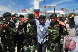 Salah satu sandera bernama Badar (tengah) tiba di Skouw, Kota Jayapura, Papua, Jumat (18/9). Dua sandera WNI Sudirman dan Badar dibebaskan dari kelompok bersenjata kepada pihak militer PNG, Kamis (17/09) malam sekitar pukul 22.00 waktu PNG. ANTARA FOTO/Indrayadi/wdy/15.