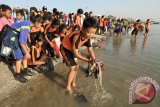 Sejumlah siswa memunguti sampah di sepanjang pantai Kenjeran Surabaya, Jawa Timur, Minggu (20/9). Kegiatan bersih-bersih pantai Kenjeran yang diikuti sampai 12 ribu siswa SD, SMP, SMA dan masyarakat umum tersebut merupakan gerakan peduli lingkungan hidup. Antara Jatim/Didik Suhartono/zk/15