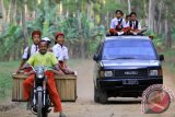 Puluhan siswa sekolah dasar berangkat ke sekolah menaiki mobil angkut dan motor di Jayengan, Banyuwangi, Jawa Timur, Selasa (22/9). Mobil tersebut menjadi alat transportasi sekolah di pedalaman lereng Gunung Raung yang mengangkut sebanyak 36 siswa dan melintasi jalan sulit yang berjarak sekitar 2 kilometer. Antara Jatim/ Budi Candra Setya/zk/15.