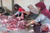 Sejumlah perempuan memotong daging kurban di halaman RS Muhammadiyah, Kediri, Jawa Timur, Rabu (23/9). Di tempat ini, dipotong tiga ekor sapi serta tujuh ekor kambing yang dibagikan ke 1320 warga penerima di Kota Kediri. Antara jatim/Foto/Asmaul Chusna 
