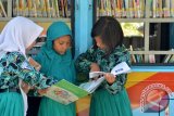 Sejumlah pelajar membaca buku milik perpustakaan keliling disela-sela Hari Aksara Internasional (HAI) di Sidoarjo, Jawa Timur, Rabu (23/9). Kegiatan tersebut bertujuan untuk memberantas buta aksara dan meningkatkan minat pelajar dalam bidang membaca dan menulis. Antara Jatim/Umarul Faruq/zk/15
