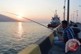 Pengunjung memancing di Pelabuhan Baru Panarukan, Situbondo, Jawa Timur, Jumat (25/9). Dermaga dengan panjang 200 meter merupakan dermaga Pelabuhan Baru Panarukan yang tiap hari banyak dikunjungi warga untuk memancing ikan, menjaring ikan, menikmati sore atau malam hari dengan makan aneka makanan dari laut. Antara Jatim/Seno/15.