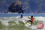 Peselancar cilik Dani W asal Bali beraksi dalam kejuaraan nasional surfing usia 14 tahun di Pulau Merah, Banyuwangi, Jawa Timur, Jumal (25/9). Surfing kelas pemula yang diikuti 30 peserta di bawah U-14 dan U-16 tersebut bertujuan untuk mencari bibit atlet nasional. ANTARA FOTO/ Budi Candra Setya/wdy/15.