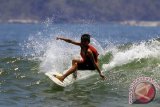 Peselancar cilik Dani W asal Bali beraksi dalam kejuaraan nasional surfing usia 14 tahun di Pulau Merah, Banyuwangi, Jawa Timur, Jumal (25/9). Surfing kelas pemula yang diikuti 30 peserta di bawah U-14 dan U-16 tersebut, bertujuan untuk mencari bibit Atlit nasional. Antara Jatim/ Budi Candra Setya/15.