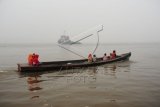 Sebuah perahu motor melintasi Sungai Kapuas yang diselimuti kabut asap tebal di Kabupaten Kubu Raya, Kalbar, Jumat (25/9). Dari hasil pantauan Satelit AQUA/Terra Modis milik BMKG per 25 September, tidak terdapat titik api di wilayah Kalbar namun hingga kini kabut asap yang semakin pekat masih melanda Kabupaten Kubu Raya dan Kota Pontianak. ANTARA FOTO/Jessica Helena Wuysang/pd/15