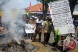 Sejumlah petani berdemonstrasi dengan membakar daun tembakau kering di halaman Gedung DPRD Kabupaten Jember, Senin (28/9). Pembakaran itu sebagai bentuk protes terhadap Pemkab dan DPRD Jember yang tidak peduli dengan nasib petani tembakau karena tembakau tidak laku dijual. Antara Jatim/Zumrotun Solichah/zk/15