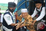 Petugas menolong seorang haji kelompok terbang pertama debarkasi Surabaya turun dari bus di Asrama Haji Sukolilo Surabaya, Selasa (29/9). Total jamaah kloter pertama asal Magetan dan Surabaya berjumlah 448 orang yang terdiri dari 217 orang laki-laki dan 231 orang perempuan. Antara Jatim/Fiqih Arfani/zk/15