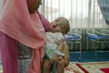 Bayi berusia empat bulan bernama Gibran digendong oleh ibunya di Posko Evakuasi Korban Asap di Kantor Wali Kota Pekanbaru, Riau, Rabu (30/9). Pemerintah Kota Pekanbaru mengubah dua ruangan di kantor balai kota untuk evakuasi bayi dan anak-anak, khususnya bagi warga yang kurang mampu dan bayi penderita gizi buruk. ANTARA FOTO/FB Anggoro/pd/15.
