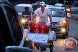 Warga Skotlandia Scott Thompson mengayuh becak dari Banda Aceh menuju Jakarta melintas di Kota Lhokseumawe, Provinsi Aceh, Senin (28/9). Aksi mengayuh becak selama 22 hari kedepan sejauh 2.612 kilometer melintasi delapan provinsi Aceh-Jakarta itu untuk memecahkan rekor dunia dari Guinness World Records untuk kategori Longest Journey by Rickshaw (Perjalanan Terjauh dengan Becak) bagian pengumpulan dana bagi penderita kanker di empat yayasan, yakni YCAB Foundation, Mary's Cancer Kiddies, Wisma Cheshire dan Yayasan Puspita. ANTARA FOTO/Rahmad/wdy/15