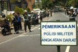 Petugas Polisi Militer memeriksa kelengkapan surat kendaraan yang melintas di perbatasan Jabar-Jateng di jalan raya Siliwangi, Desa Mekarharja, Banjar, Jawa Barat, Rabu (30/9). Razia gabungan yang terdiri dari Polisi Militer (PM) Angkatan Darat Denpom III/2-4 Banjar, Denpom IV/1-1 Cilacap, Polres Banjar dan Dishub Banjar itu digelar untuk memeriksa fisik kendaraan, ijin mengemudi militer, penertiban atribut atau simbol militer yang digunakan warga sipil, serta penertiban anggota TNI-Polri yang berada di luar tanpa ijin atasan. ANTARA FOTO/Adeng Bustomi/aww/15.