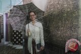 Putri pertama Sri Sultan HB X, GKR Mangkubumi saat berpose dengan payung batik pada pameran dalam rangka memperingati Hari Batik Nasional di Kraton Yogyakarta, Jumat (2/10). GKR Mangkubumi mewakili Daerah Istimewa Yogyakarta menerima penghargaan dari World Craft Council (WCC) di Donyang, China sebagai 'Jogja Kota Batik Dunia'. ANTARA FOTO/Regina Safri/wdy/15.