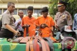 Kapolresta Banda Aceh, Kombes Pol Zulkifli , (kiri) menghadirkan dua tersangka polisi gadungan beserta barang bukti ikat pinggang dan topi saat gelar perkara di Banda Aceh, Selasa (6/10). Dua tersangka itu ditangkap karena melakukan tindak kejahatan memeras pedagang dan menyita barang dagangan dengan mengaku sebagai polisi. ANTARA FOTO/Ampelsa/pd/15